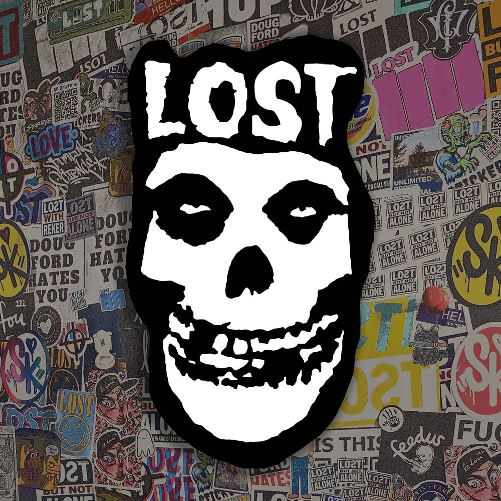 The Crimson Ghost Graffiti Sticker by LOST. A modern example of the classic black and white skull logo re-invented. The Word LOST is scrawled across the top in Bold white letters.