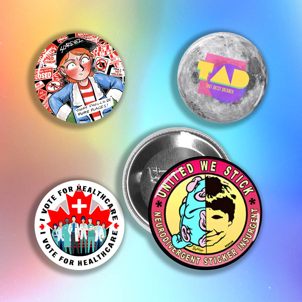 A display of four colorful custom pinback buttons made by reilly9578. The four buttons are set on a holographic rainbow background.