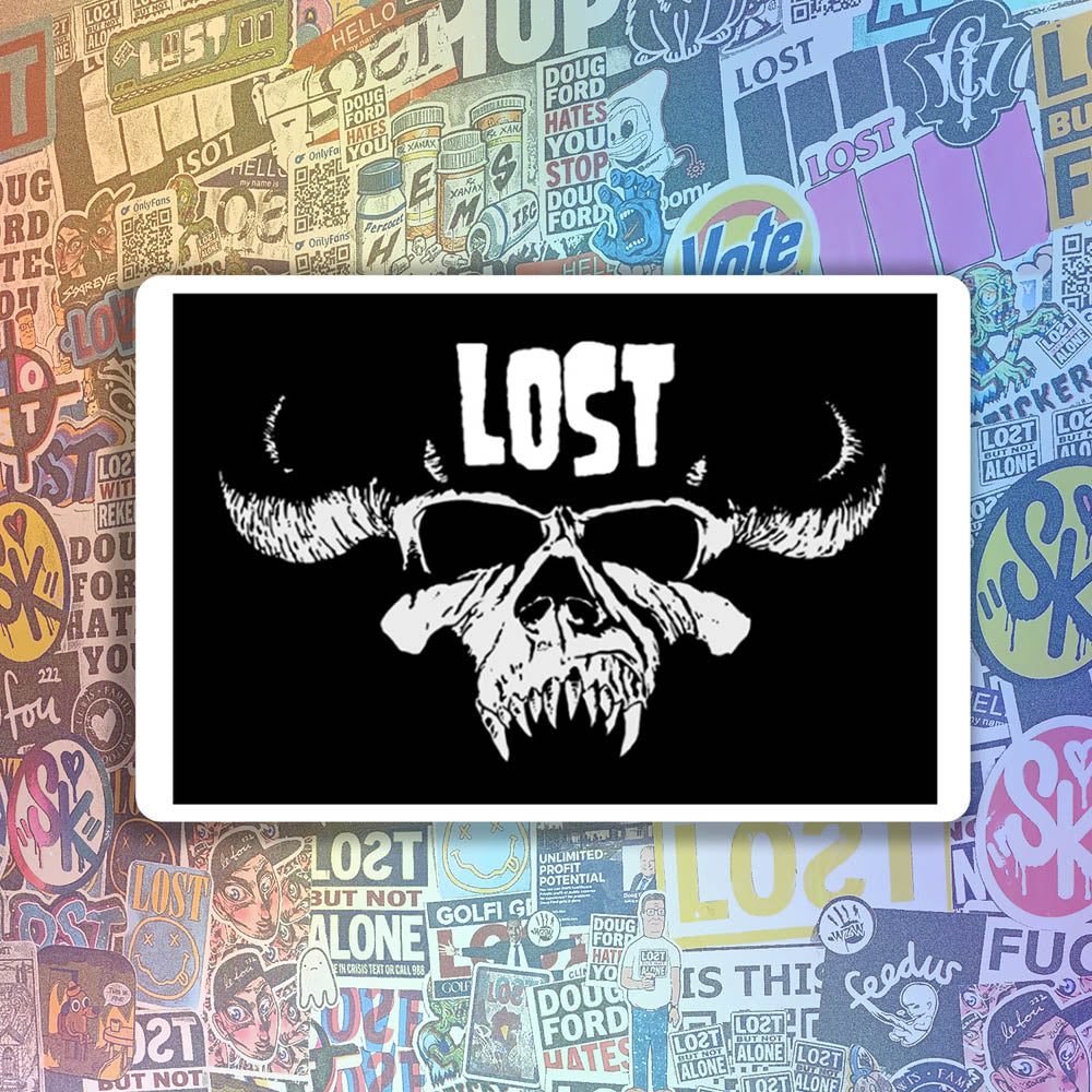 The Danzig thermal sticker by LOST. Black and white design featuring the Danzig skull with the text LOST. A wall of colorful graffiti stickers provides a unique background for the sticker.