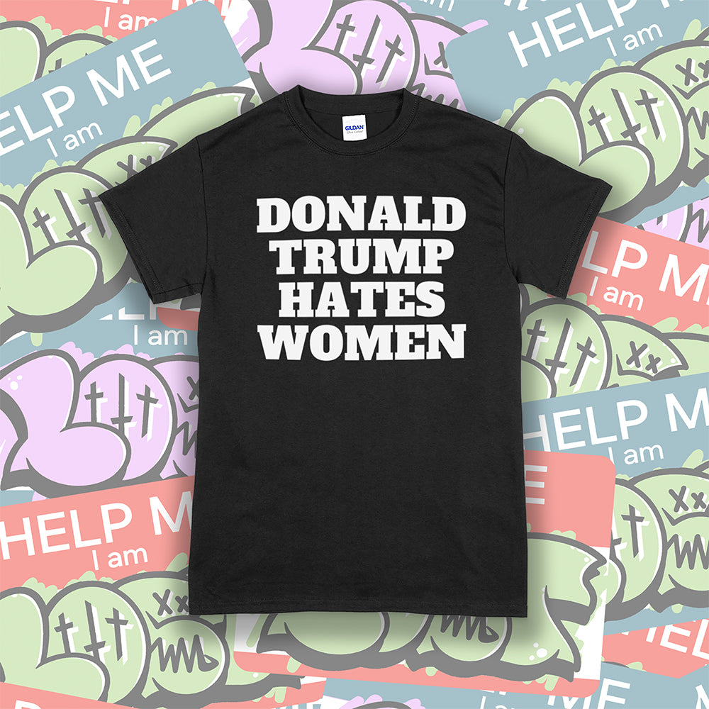 Donald Trump Hates Women t-shirt. Bold letters screen printed with white ink on a black shirt. Colorful LOST graffiti stickers are in the background.
