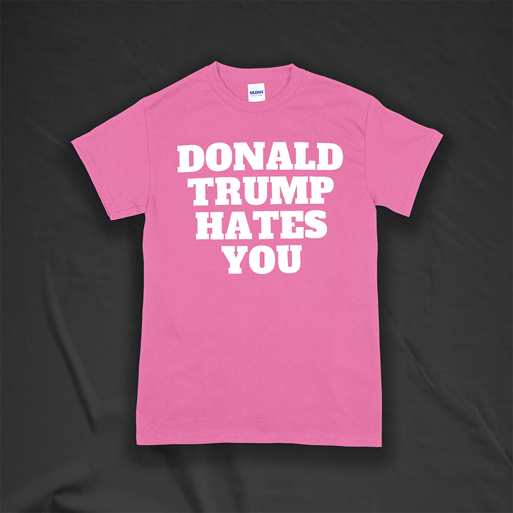 The Donald Trump Hates You t-shirt. Bold letters screen printed with white ink on a pink shirt.