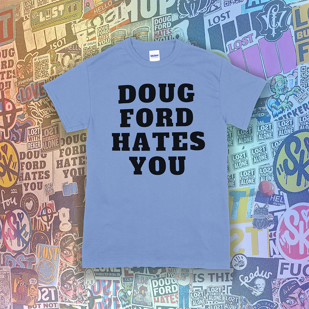 The original Doug Ford Hates You t-shirt. Bold black letters screen printed on a Carolina blue shirt. Assorted colorful graffiti stickers make up the background.