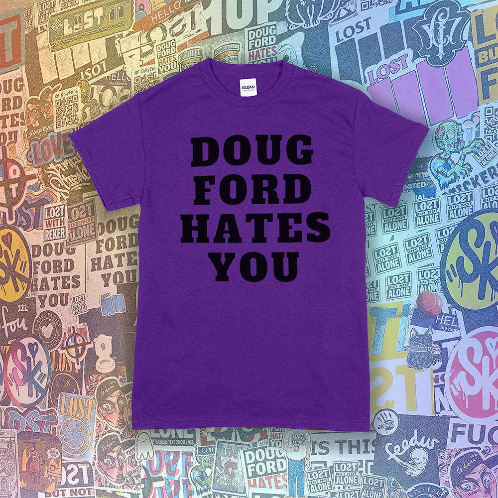 The original Doug Ford Hates You t-shirt. Bold black letters screen printed on a purple shirt. Assorted colorful graffiti stickers make up the background.