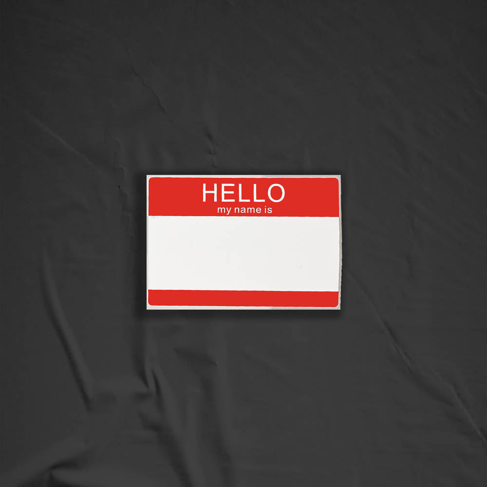 Hello my name is blank nametag sticker. A red and white nametag sticker waiting to be tagged. The sticker is set against a black background.