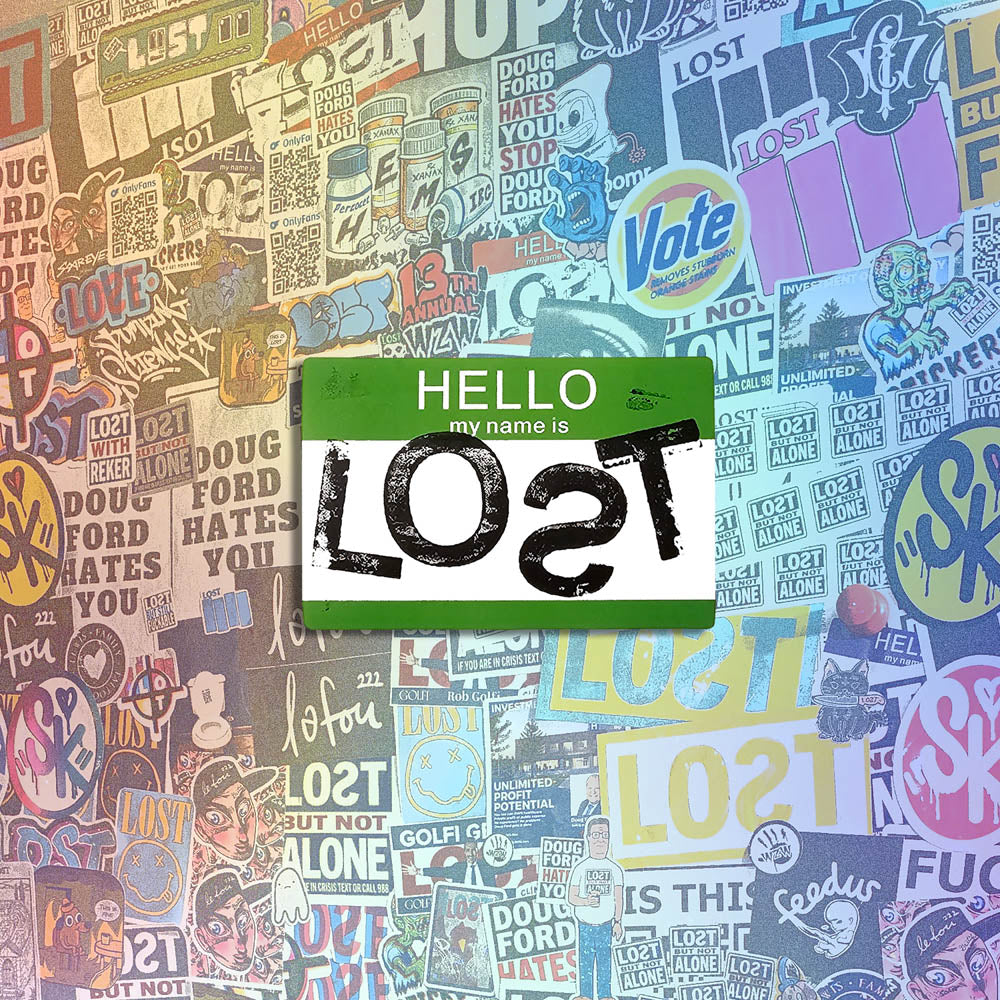 Hello my name is LOST sticker. A green and white nametag sticker stamped with the name LOST with a backwards S. The sticker is set against a wall of stickers from international graffiti artists.