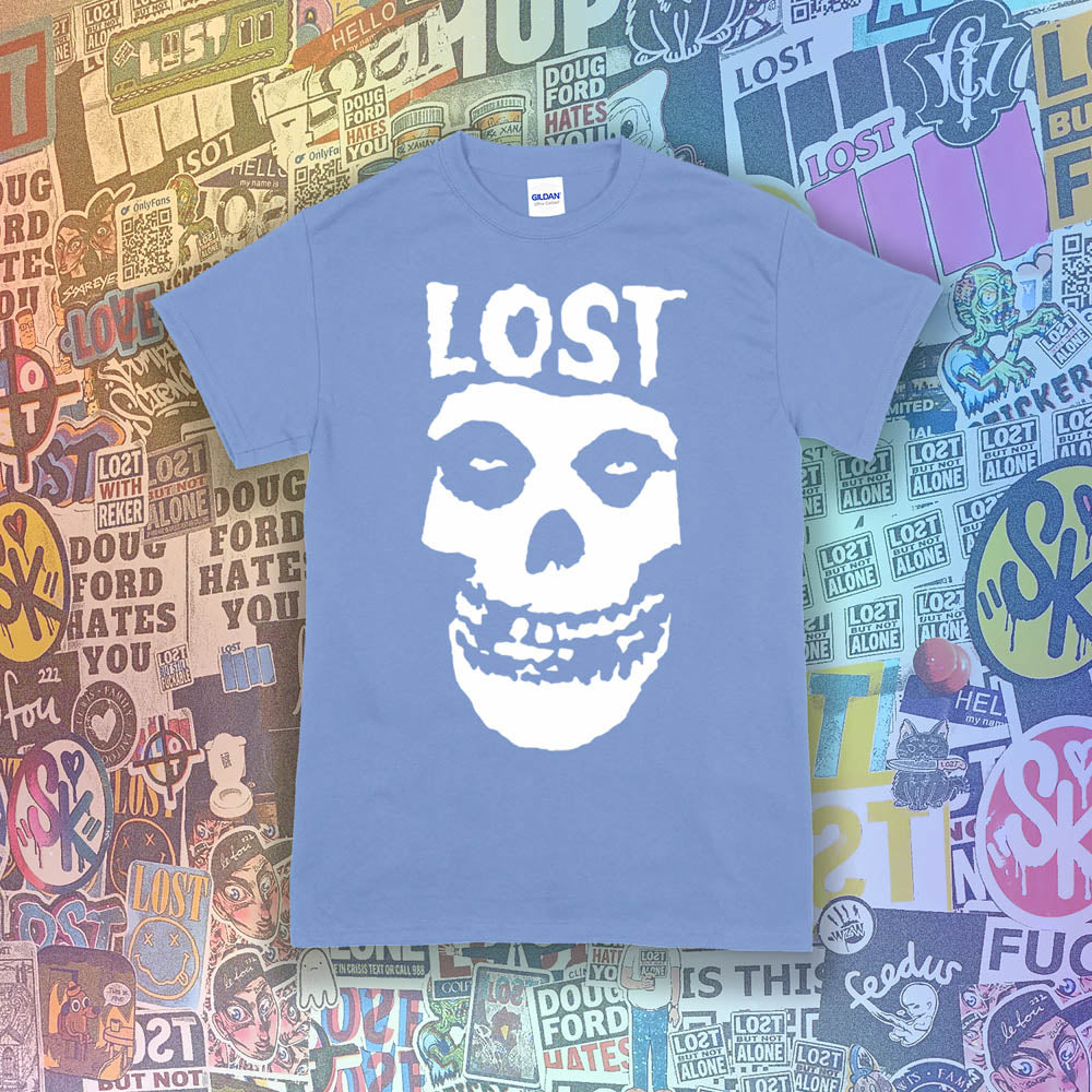 The Lost Crimson Ghost t-shirt. A Bold white skull screen printed and displayed on a light blue shirt. An assortment of graffiti stickers sets the background for this classic design upgraded by Lost Streetwear.