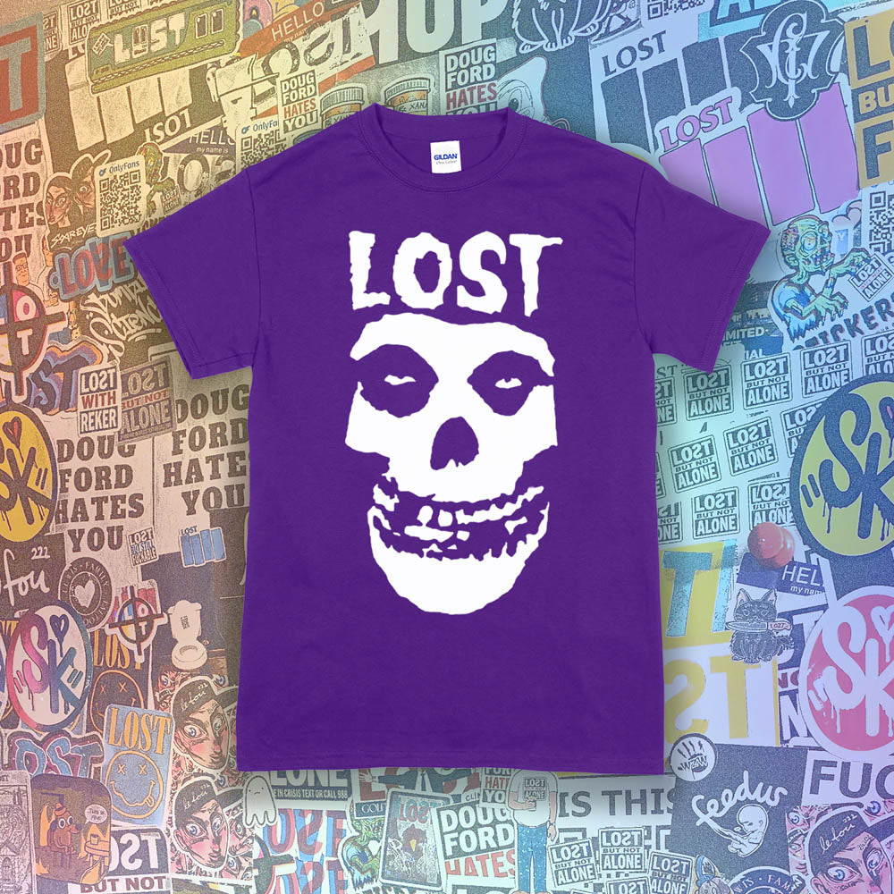 The Lost Crimson Ghost t-shirt. A Bold white skull screen printed and displayed on a deep purple shirt. An assortment of graffiti stickers sets the background for this classic design upgraded by Lost Streetwear.