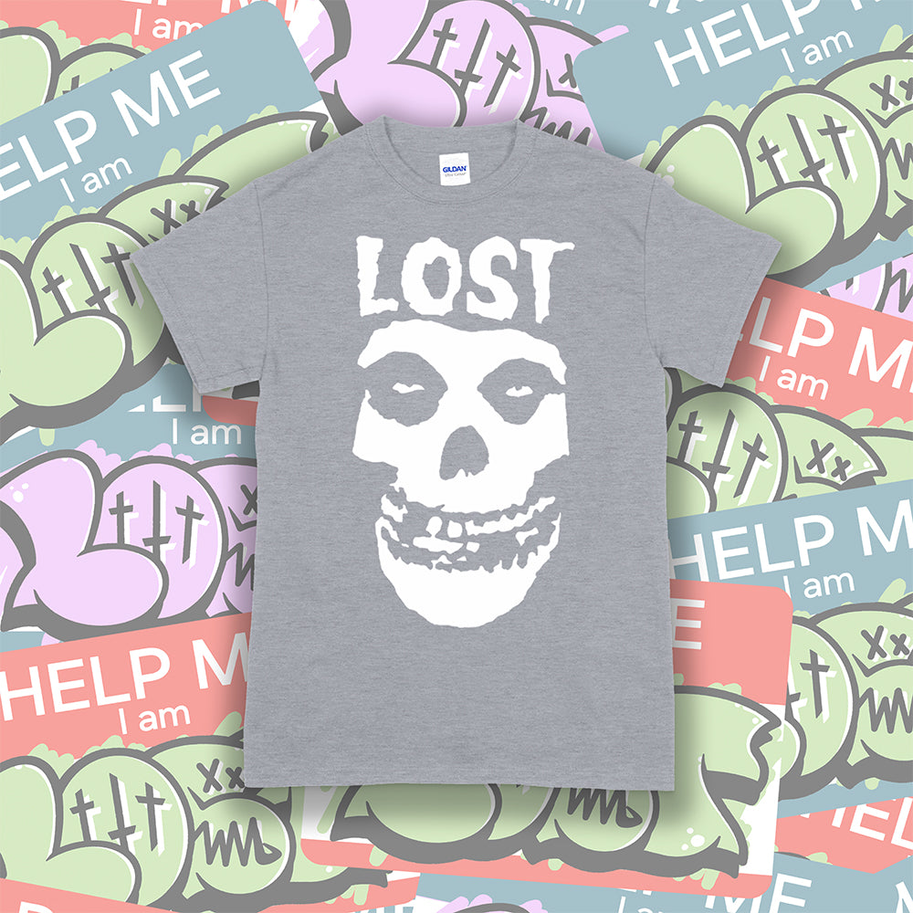 The Lost Crimson Ghost t-shirt. A Bold white skull screen printed and displayed on a grey shirt. An assortment of graffiti stickers sets the background for this classic design upgraded by Lost Streetwear.