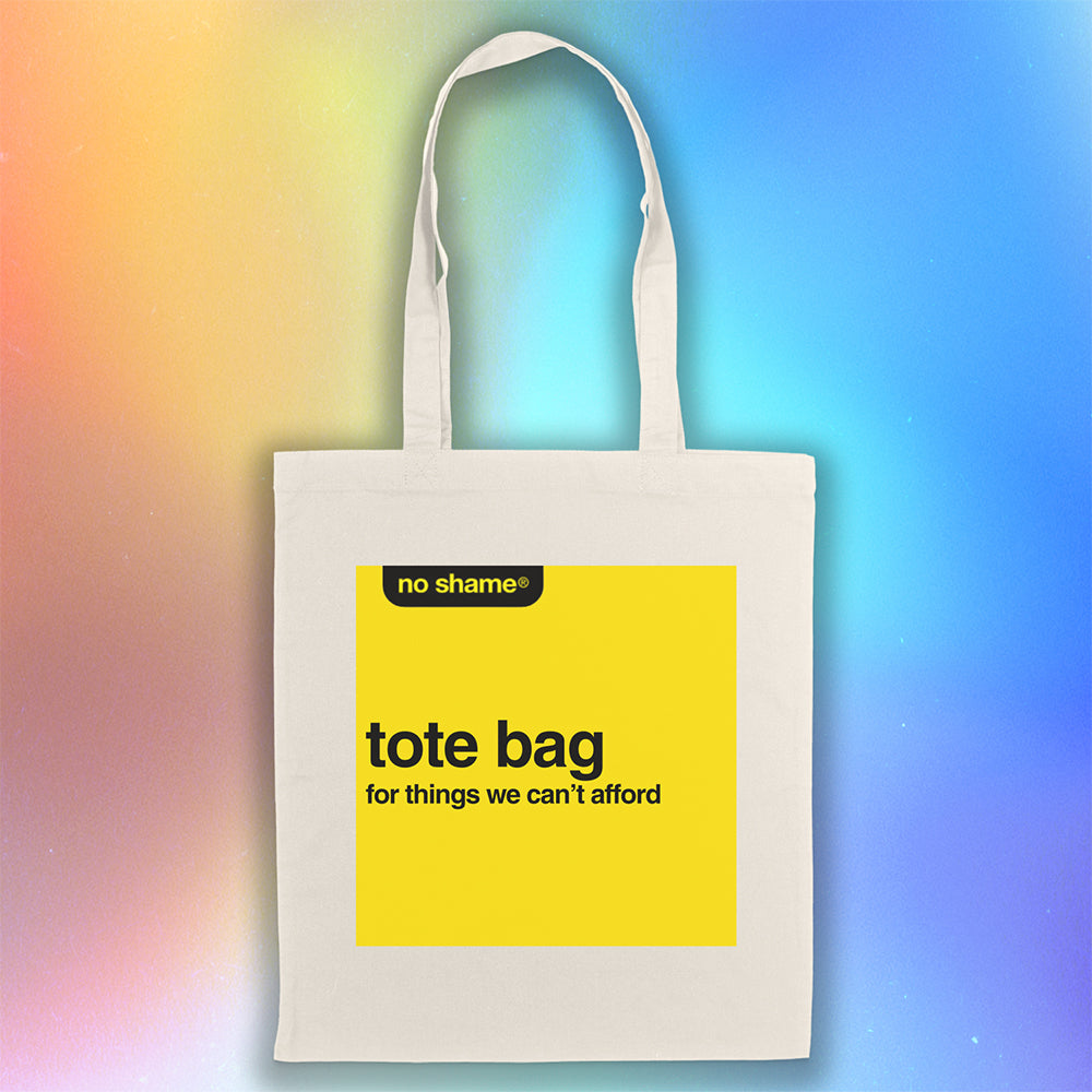 The no shame tote bag: for things we can't afford. Those words are screen  printed in bold black ink inside a no name yellow box on a large, natural canvas tote bag. A simulated holographic background creates a vibrant atmosphere for the tote bag on display.