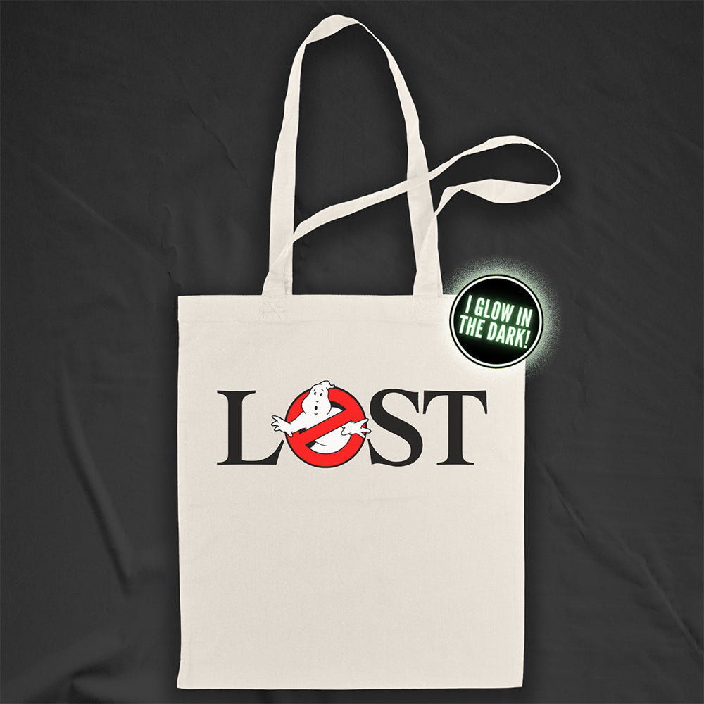 The LOSTBUSTERS tote bag features a surprised looking  ghost trapped in the O of the word LOST and vaguely resembling the original Ghostbusters logo. The crisp image is screen printed on a natural canvas tote bag. A black background provides dramatic contrast for the tote bag on display.
