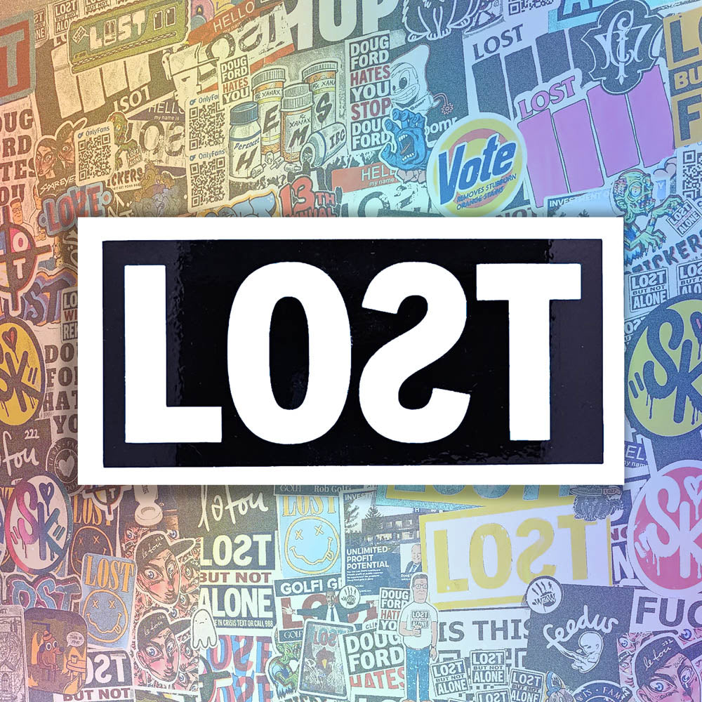 The original graffiti sticker by LOST. A simple two color cut design featuring the word LOST written with a backwards S in matte white e and contained within a glossy black rectangle. The sticker is set against a wall of colorful graffiti stickers by artists from around the world.