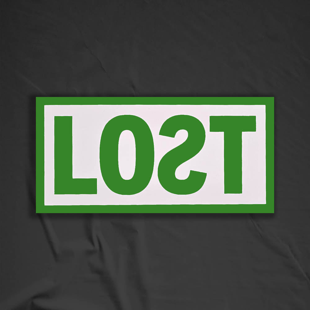 The original graffiti sticker by LOST. A simple two color cut design featuring the word LOST written with a backwards S in lime green and contained within a matte white rectangle. The sticker is set against a contrasting black background.