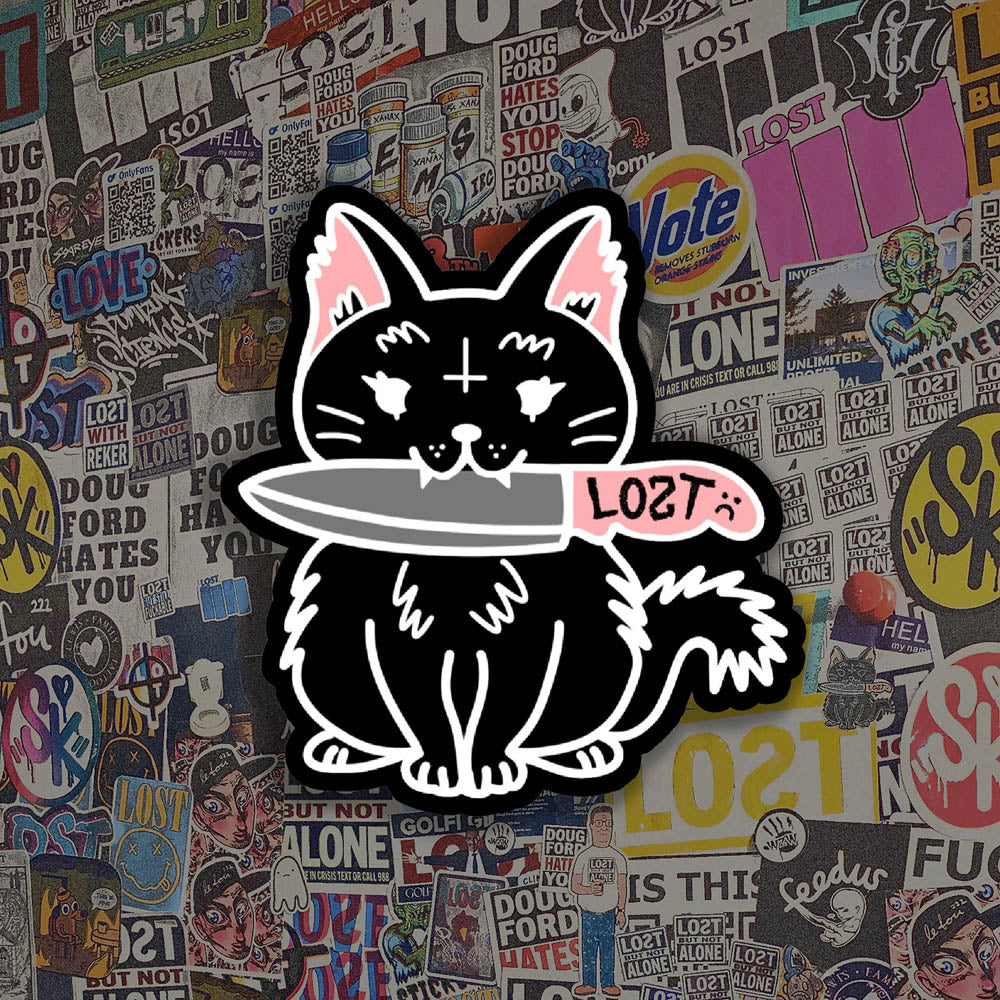 Pancake graffiti sticker. This die-cut sticker features the black cat Pancake holding a knife in her mouth. A wall of colorful graffiti stickers provides the background for this display.