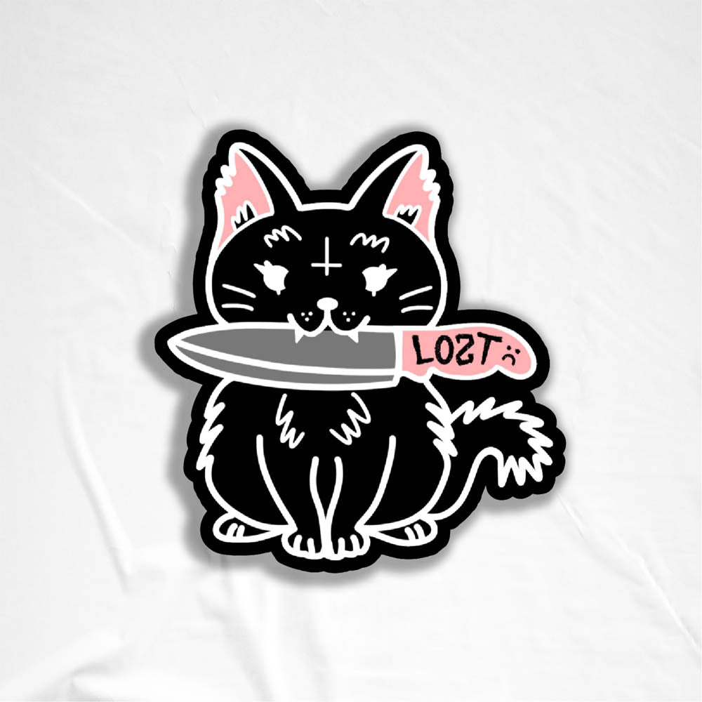 Pancake graffiti sticker. This die-cut sticker features the black cat Pancake holding a knife in her mouth. This sticker is displayed against a white background.