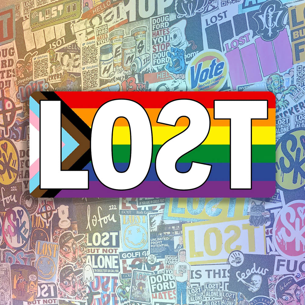 The LOST Progress graffiti sticker. The word LOST written in bold white letters on top of a rainbow progress flag. The sticker is displayed against a background of colorful graffiti stickers.