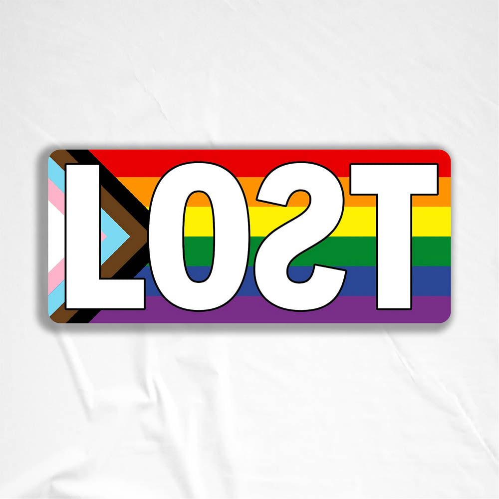 The LOST Progress graffiti sticker. The word LOST written in bold white letters on top of a rainbow progress flag. The sticker is displayed against a white background.