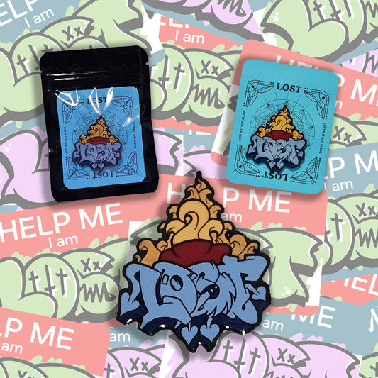 A display of three Lost Heart lapel pins. The pins feature a sacred heart and lost graffiti and is set against a graffiti sticker background.