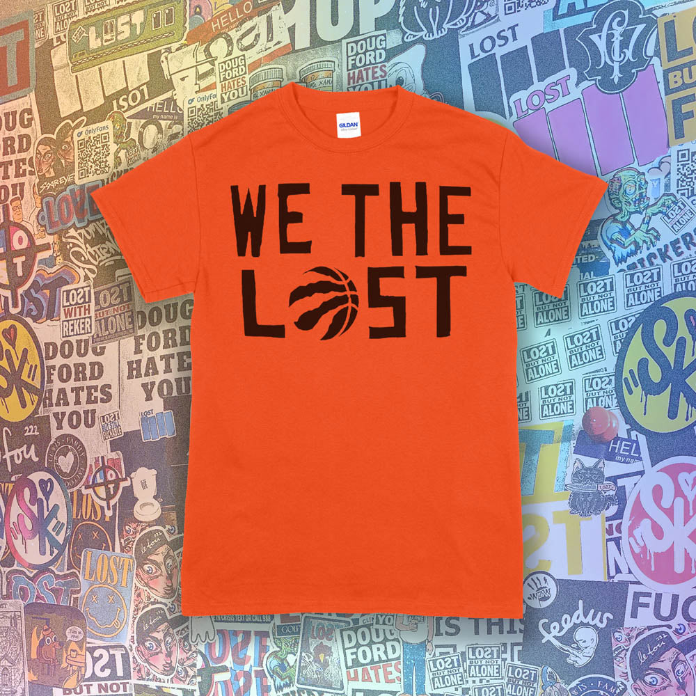 We The Lost t-shirt. Bold black lettering and raptor claw design screen printed on an orange shirt. A wall of colorful graffiti stickers make up the background.