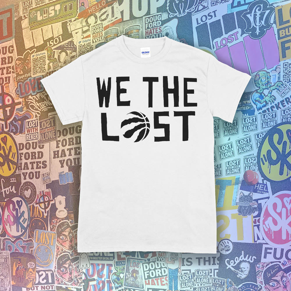 We The Lost t-shirt. Bold black lettering and raptor claw design screen printed on a bright white shirt. A wall of colorful graffiti stickers make up the background.