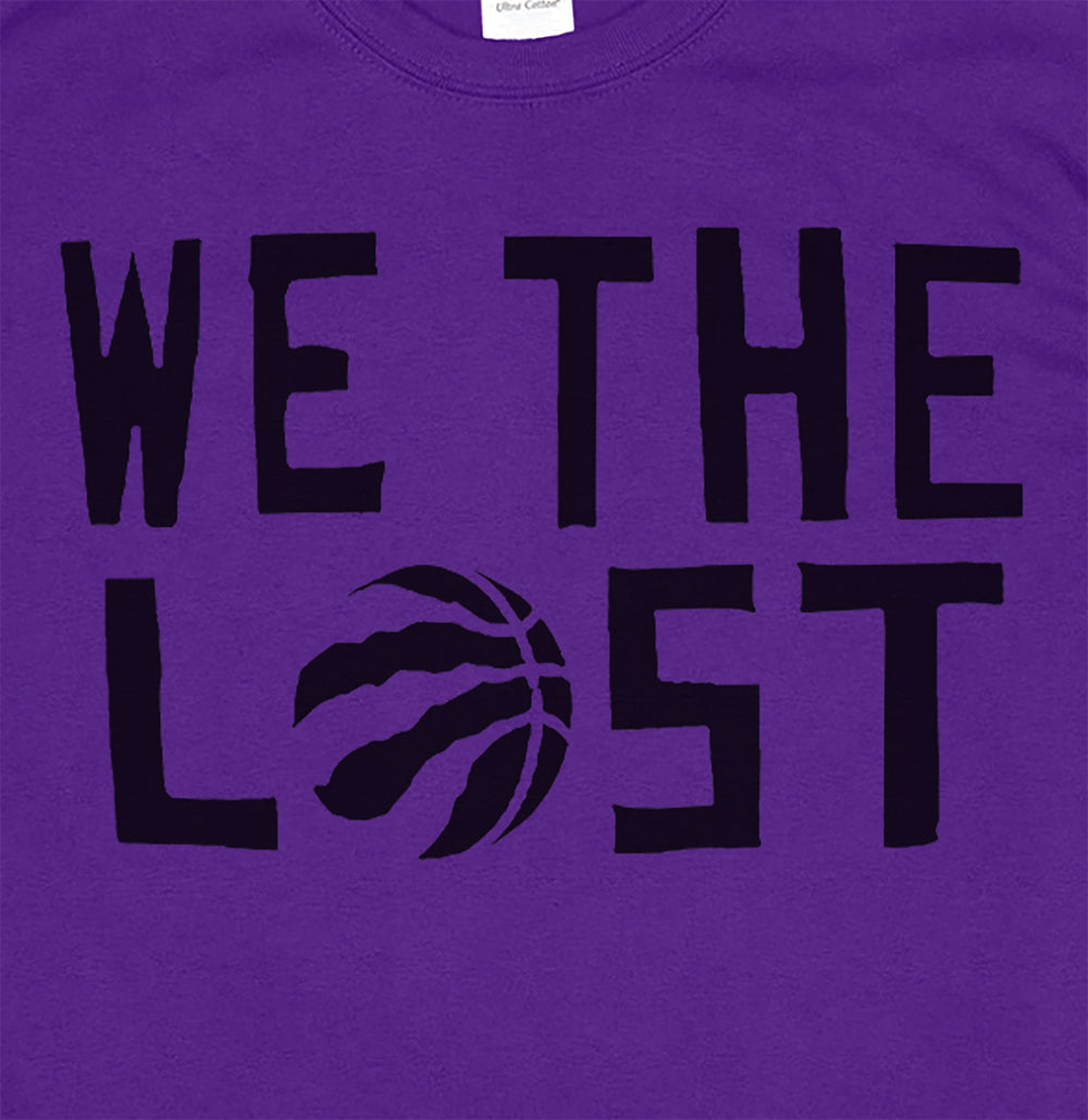 Close up view of the We The Lost t-shirt. Bold black lettering and raptor claw design screen printed onto a purple shirt.