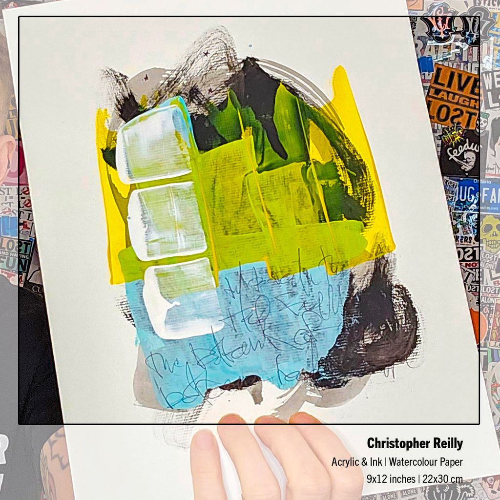 An abstract art painting on textured paper by Christopher Reilly, featuring bold brushstrokes of yellow, green, blue, black, and white. A hand is holding the bottom edge of the paper, which is set against a background of colorful stickers.