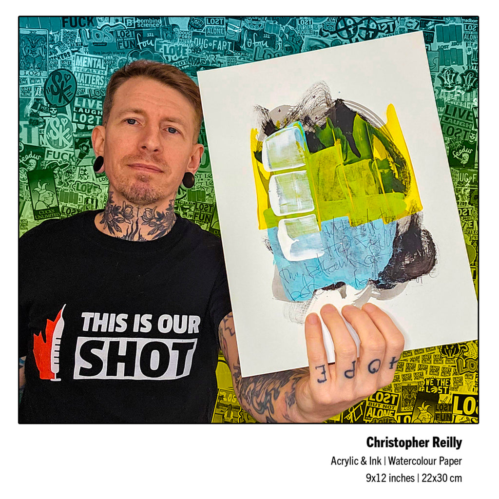 A tattooed man wearing a black graphic t-shirt holds up an abstract painting. The artwork features a mix of bright yellow-green, light blue, gray, and black paint strokes on white paper.